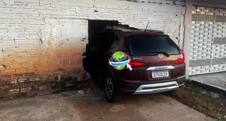 URGENTE Carro invade parede de residência e motorista foge abandonando o passageiro