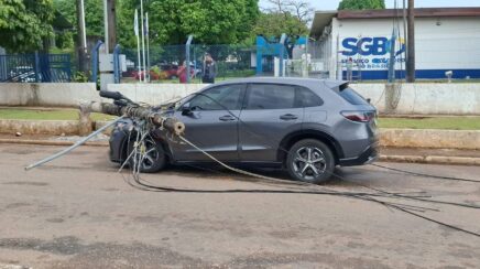 Poste cai sobre carro após carreta puxar fiação na Avenida Lauro Sodré em Porto Velho