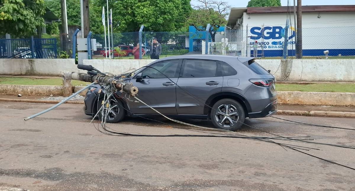 Poste cai sobre carro após carreta puxar fiação na Avenida Lauro Sodré em Porto Velho